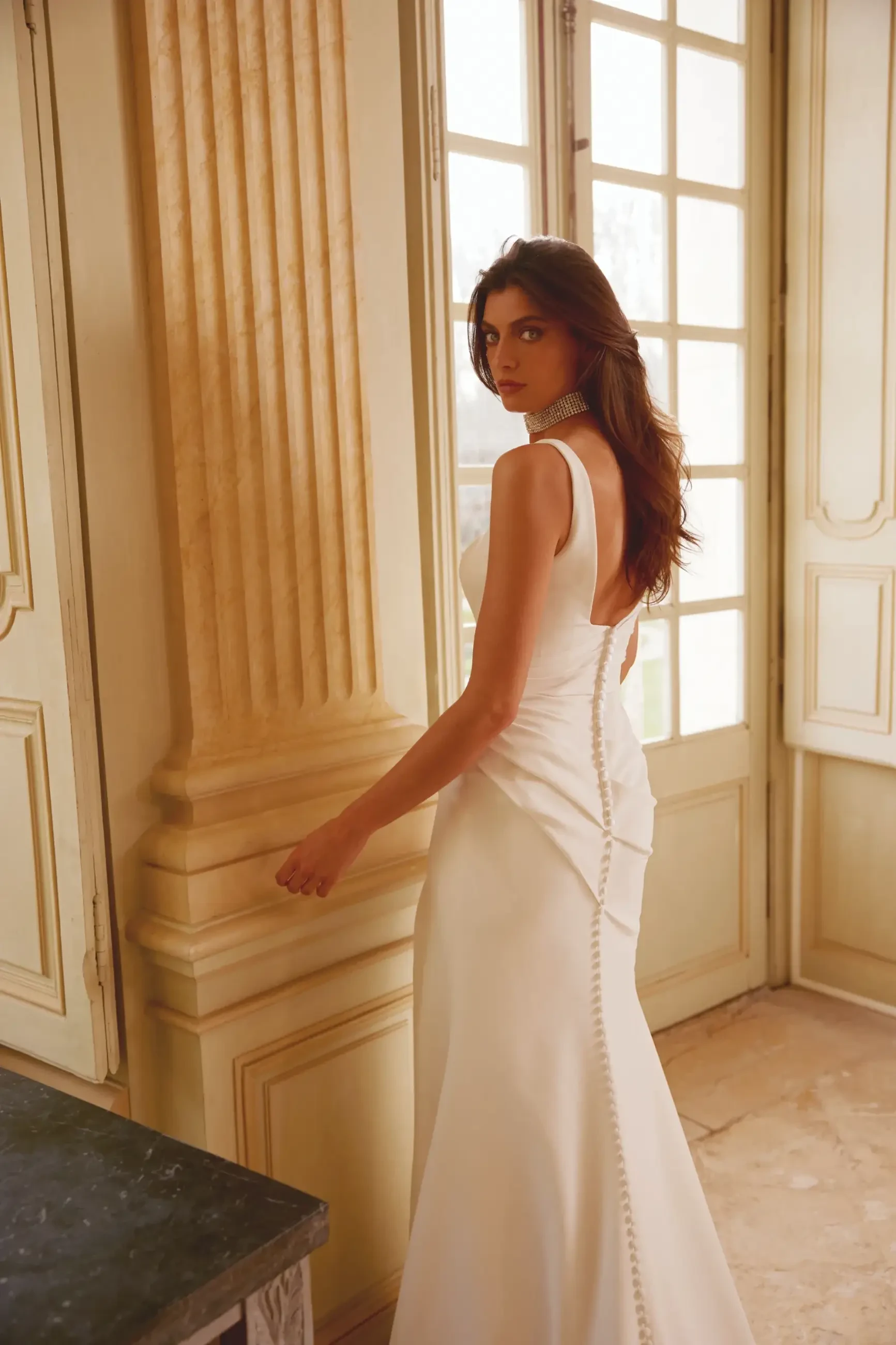 model is wearing a sleeveless square neckline satin fit and flare bridal gown