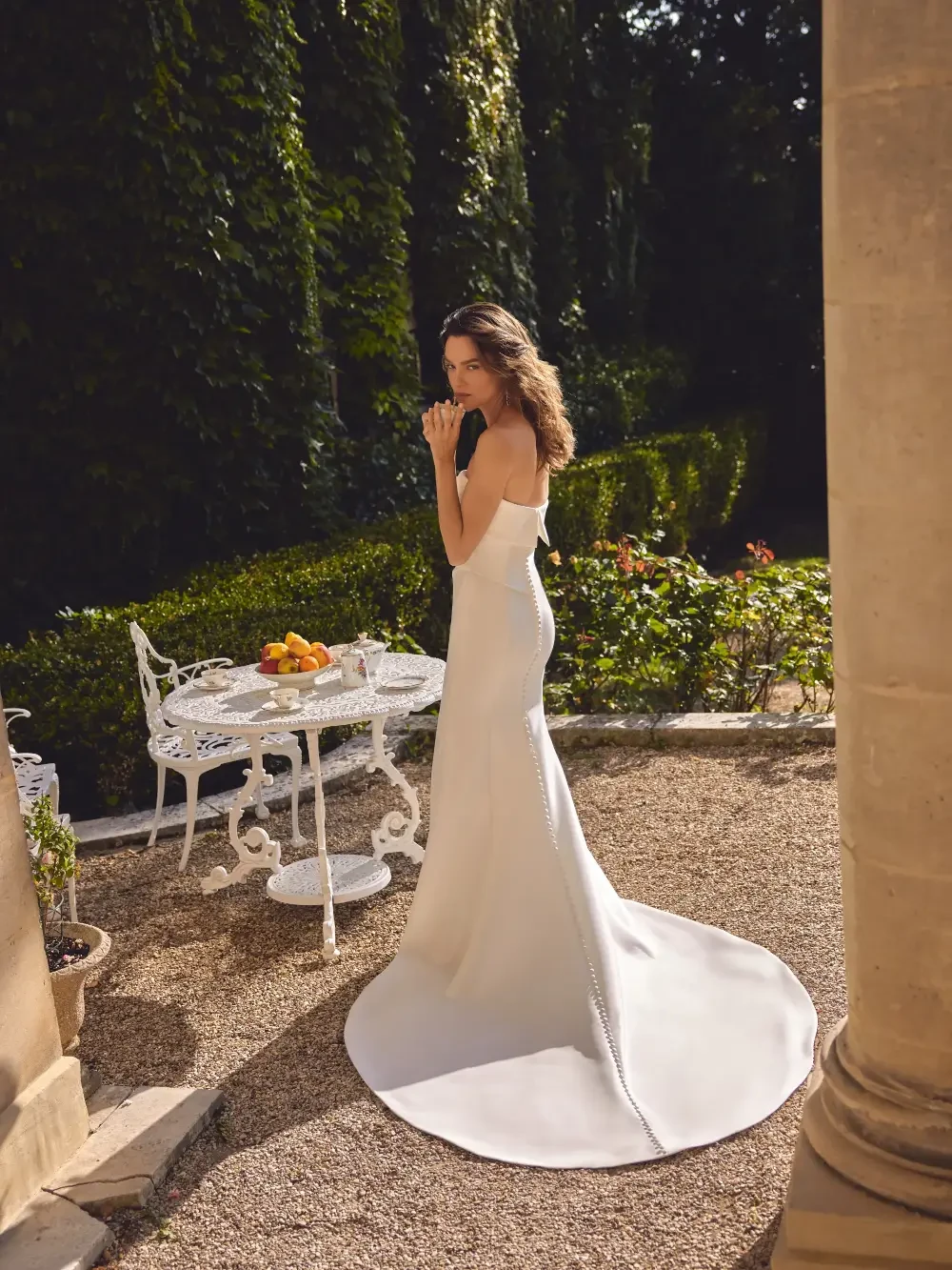 model is wearing a strapless column bridal gown