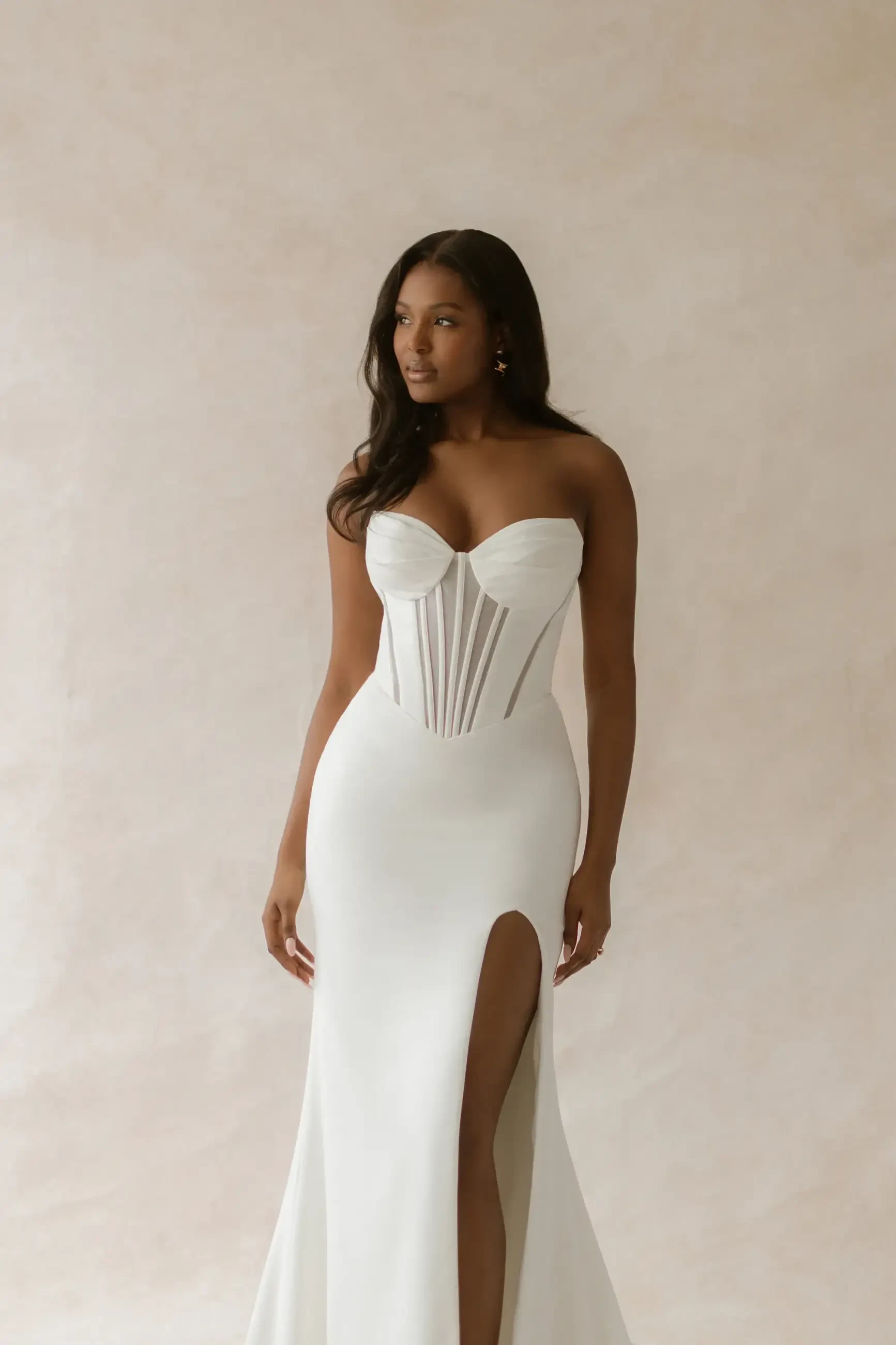 model is wearing a strapless corset bodice fit and flare wedding gown