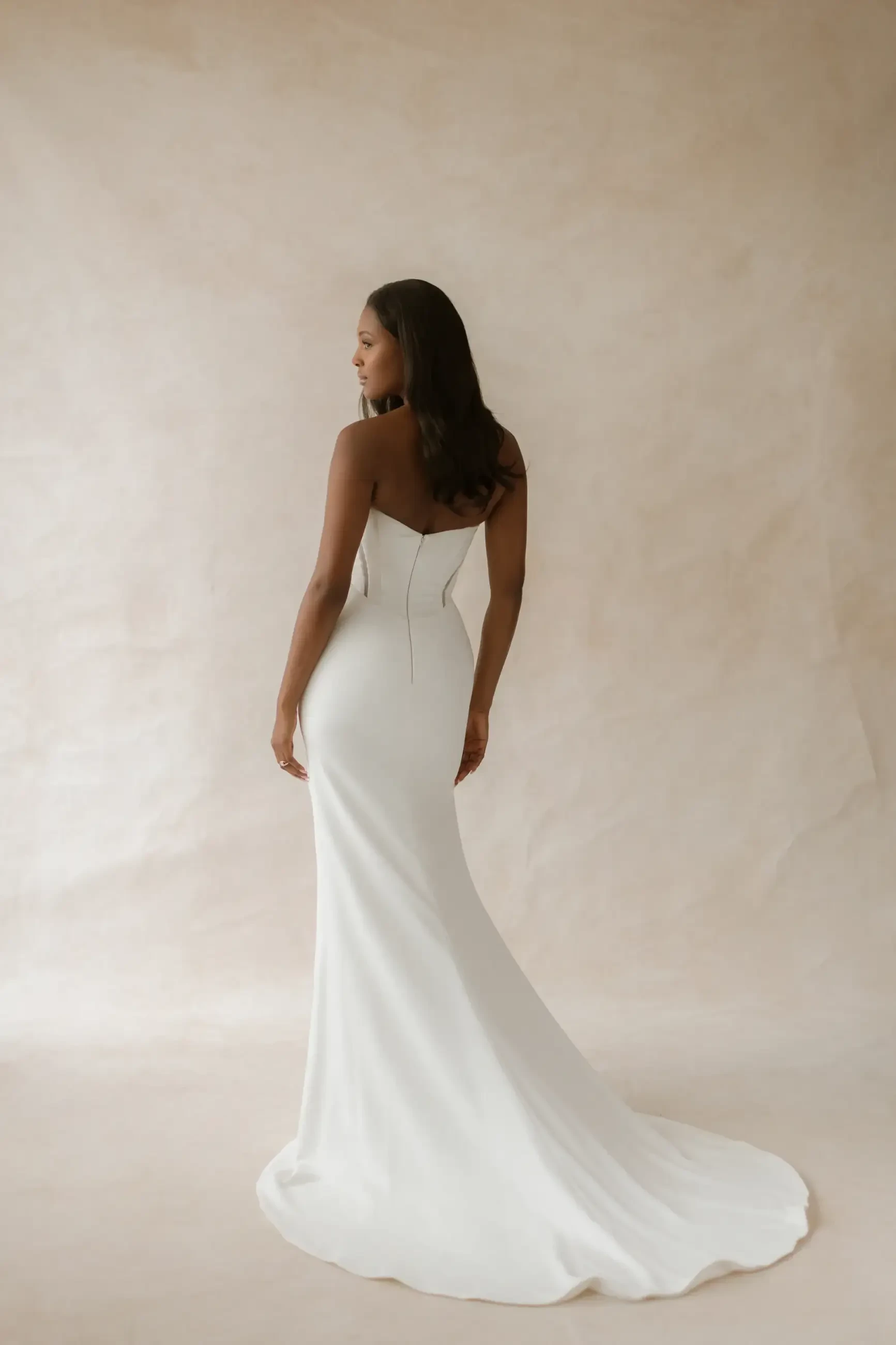 model is wearing a strapless corset bodice fit and flare wedding gown