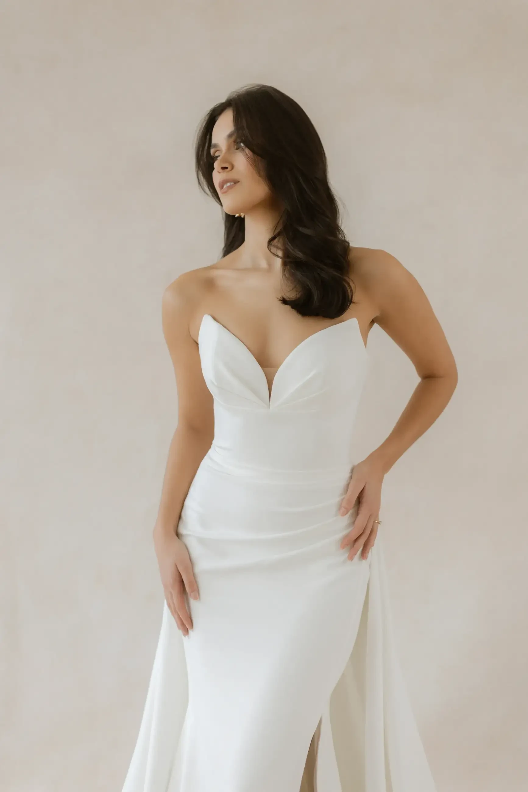 model is wearing a strapless fitted bridal gown with cat eye bodice