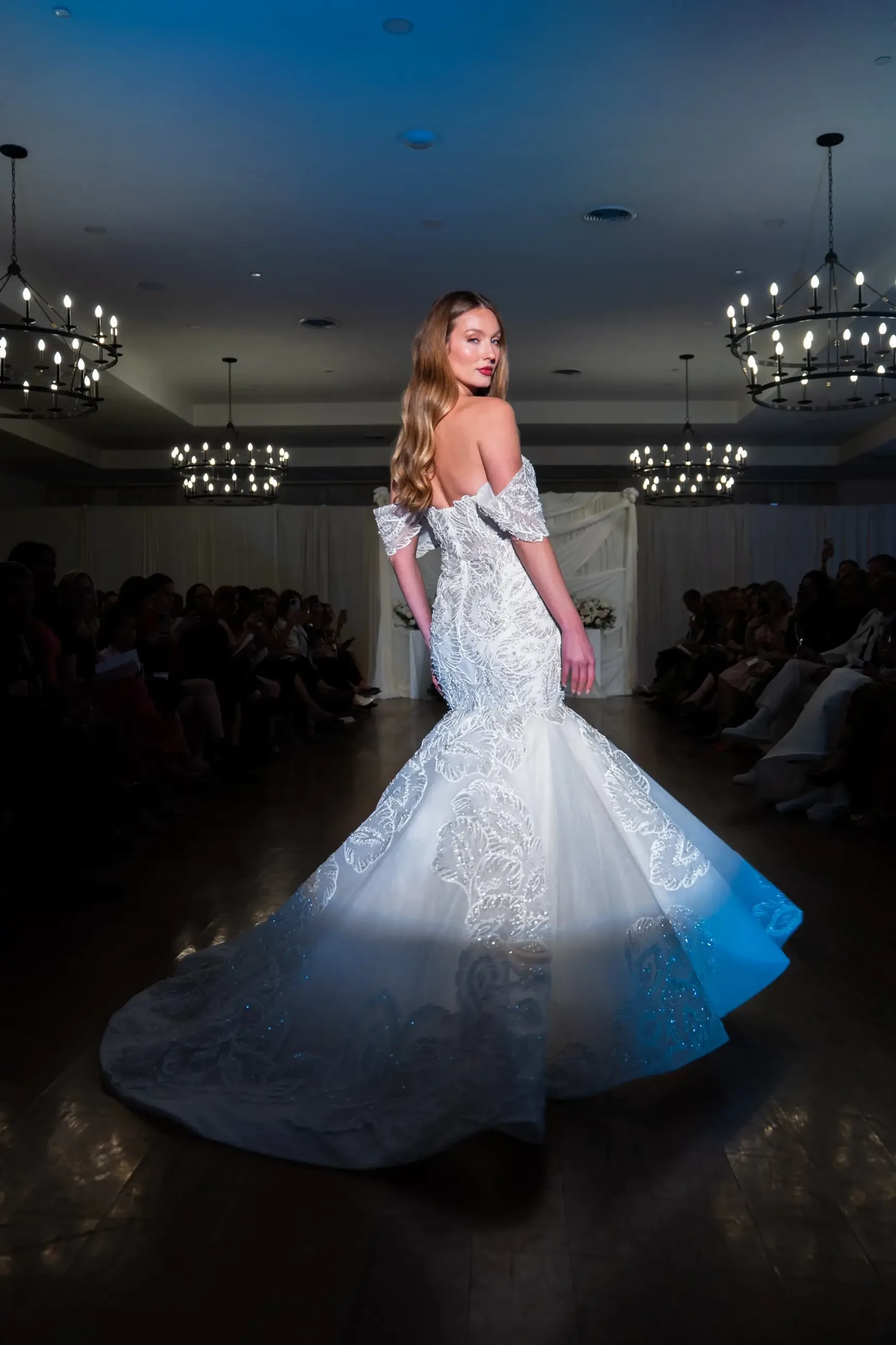 model is wearing an off the shoulder mermaid wedding dress