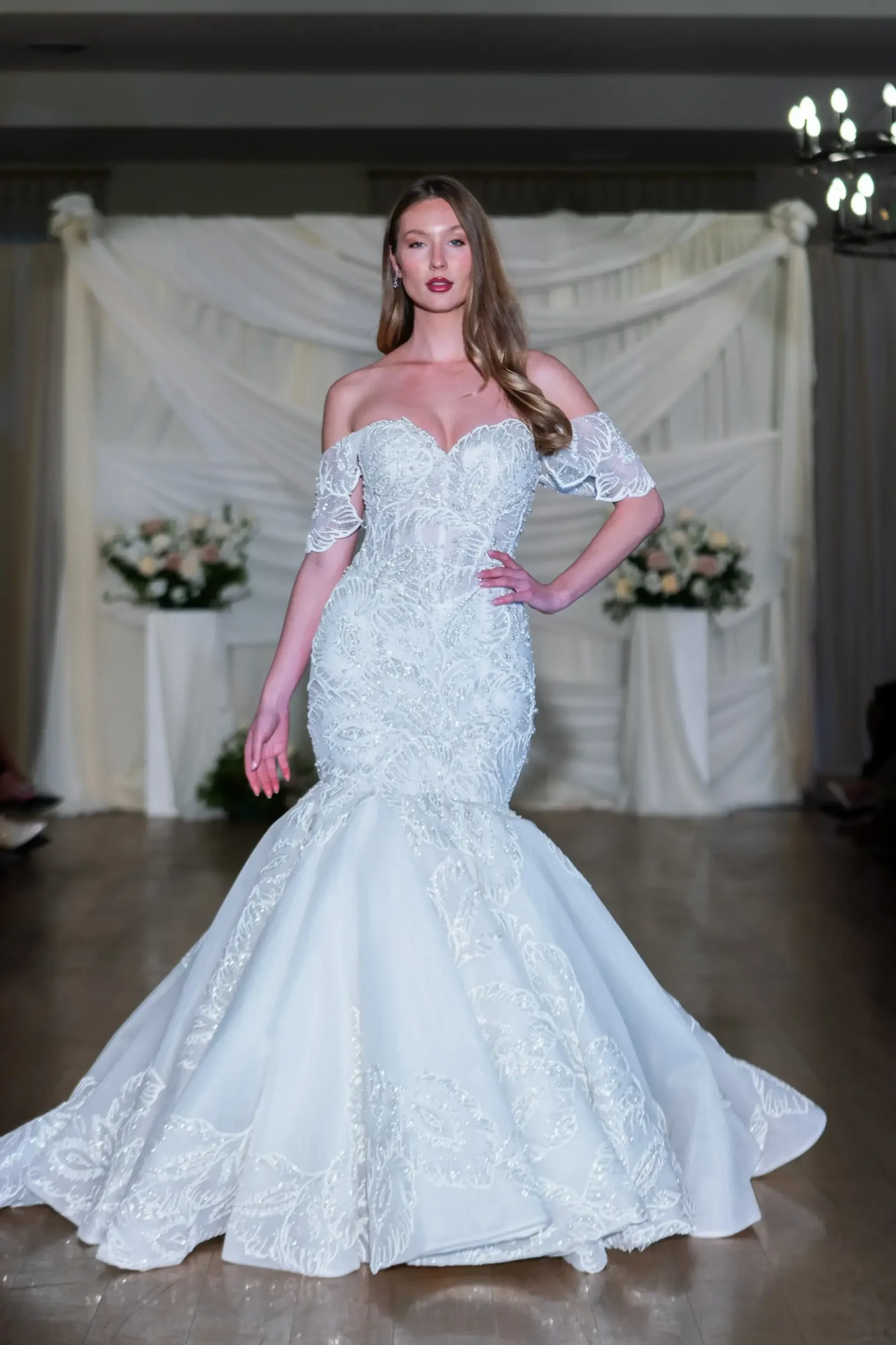 model is wearing an off the shoulder mermaid wedding dress