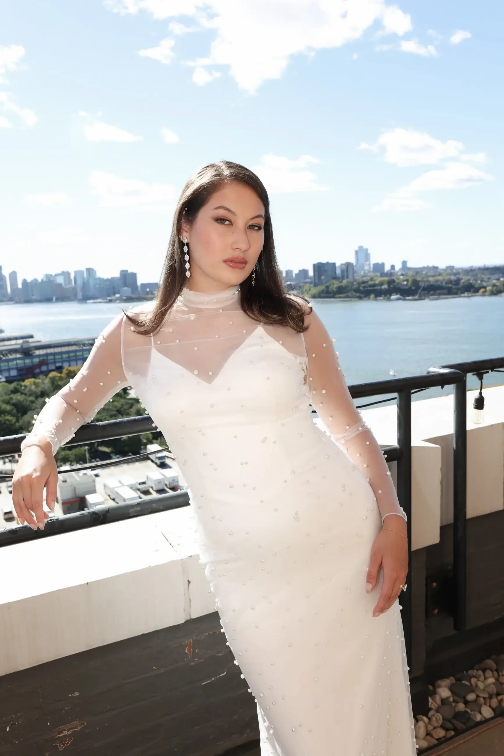 model is wearing a wedding dress with spaghetti straps and a high neck long sleeve sheer illusion piece