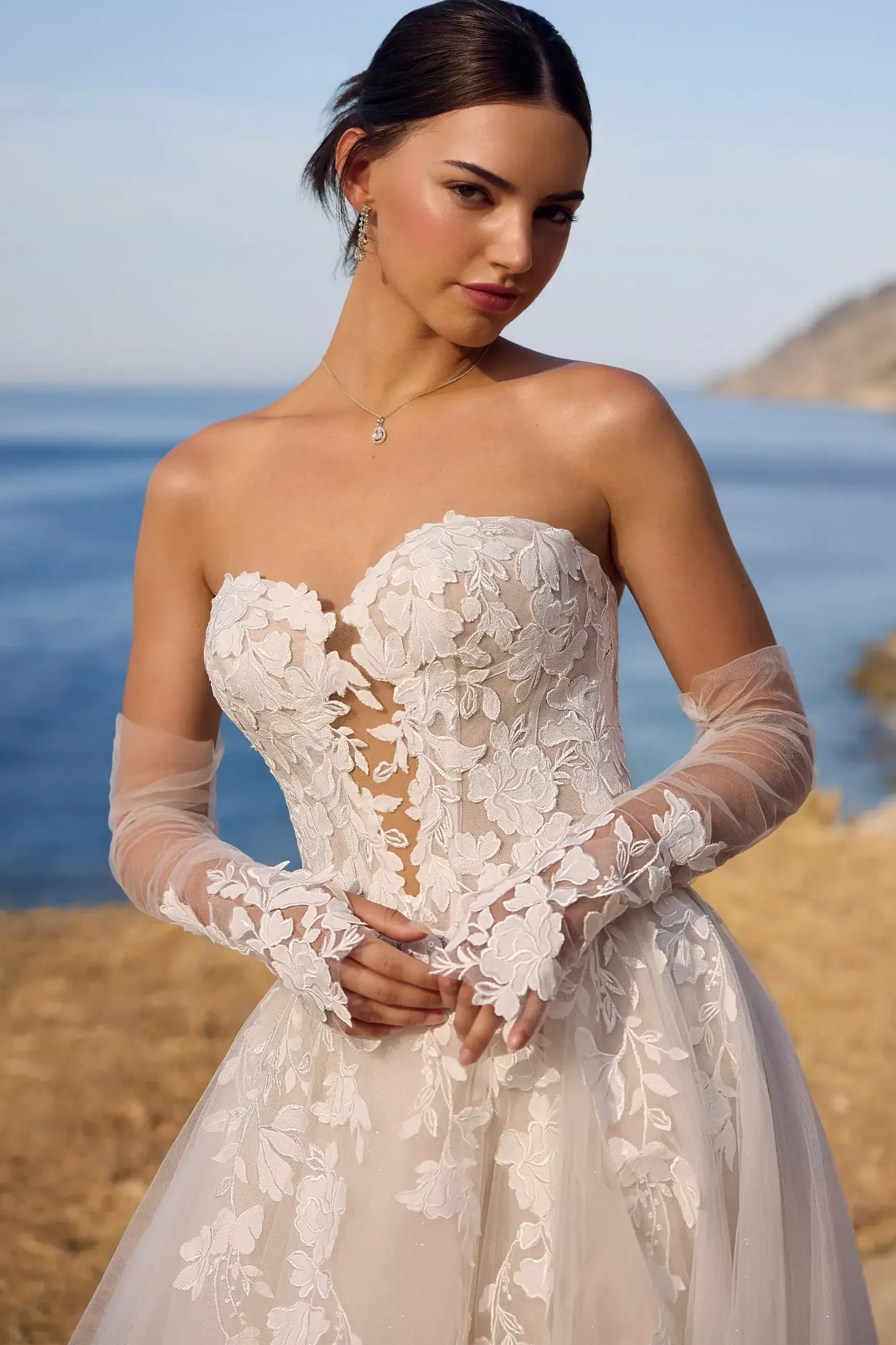 model is wearing a strapless bridal gown with detachable bridal sleeves