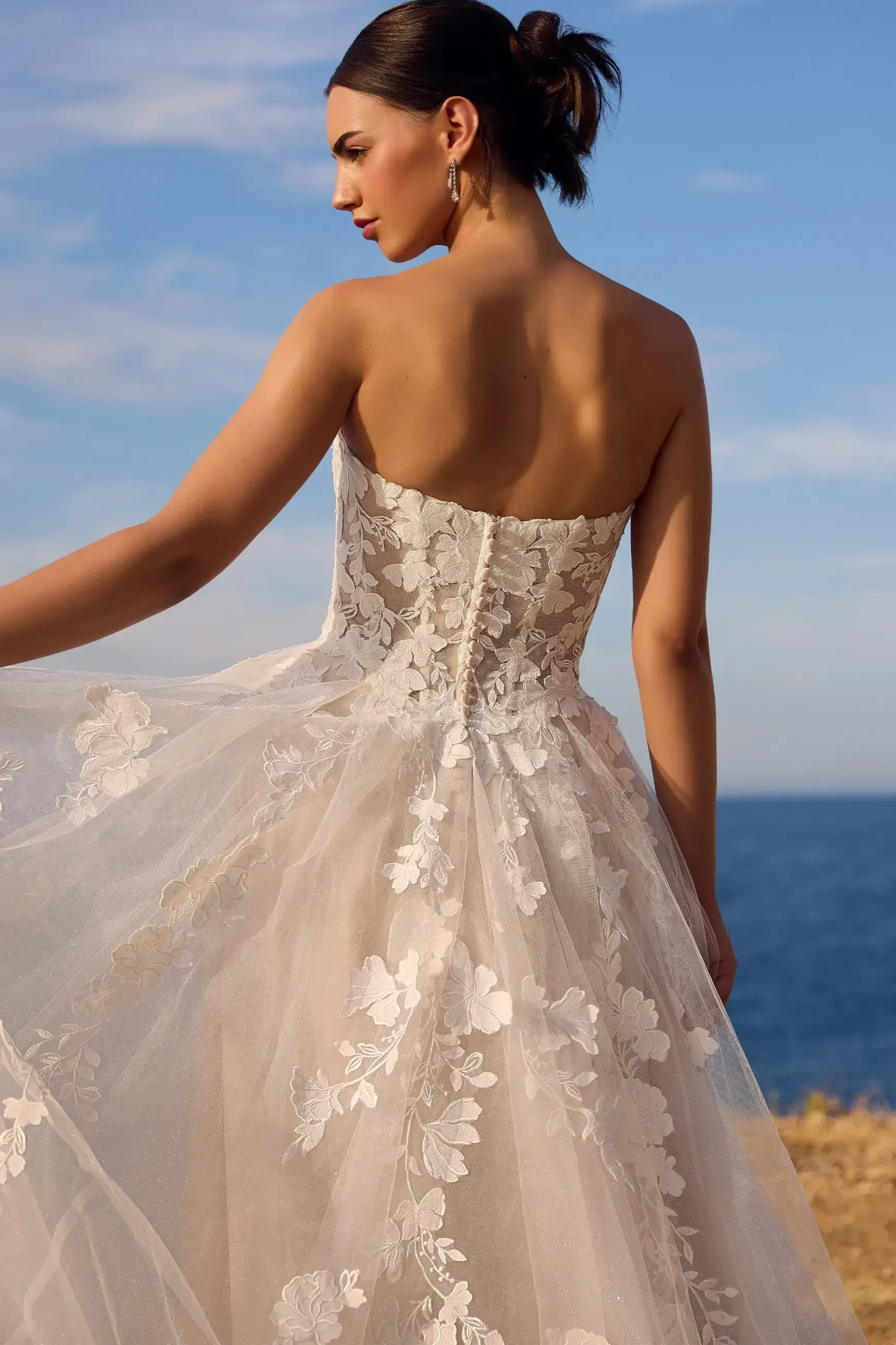 model is wearing an open back wedding dress